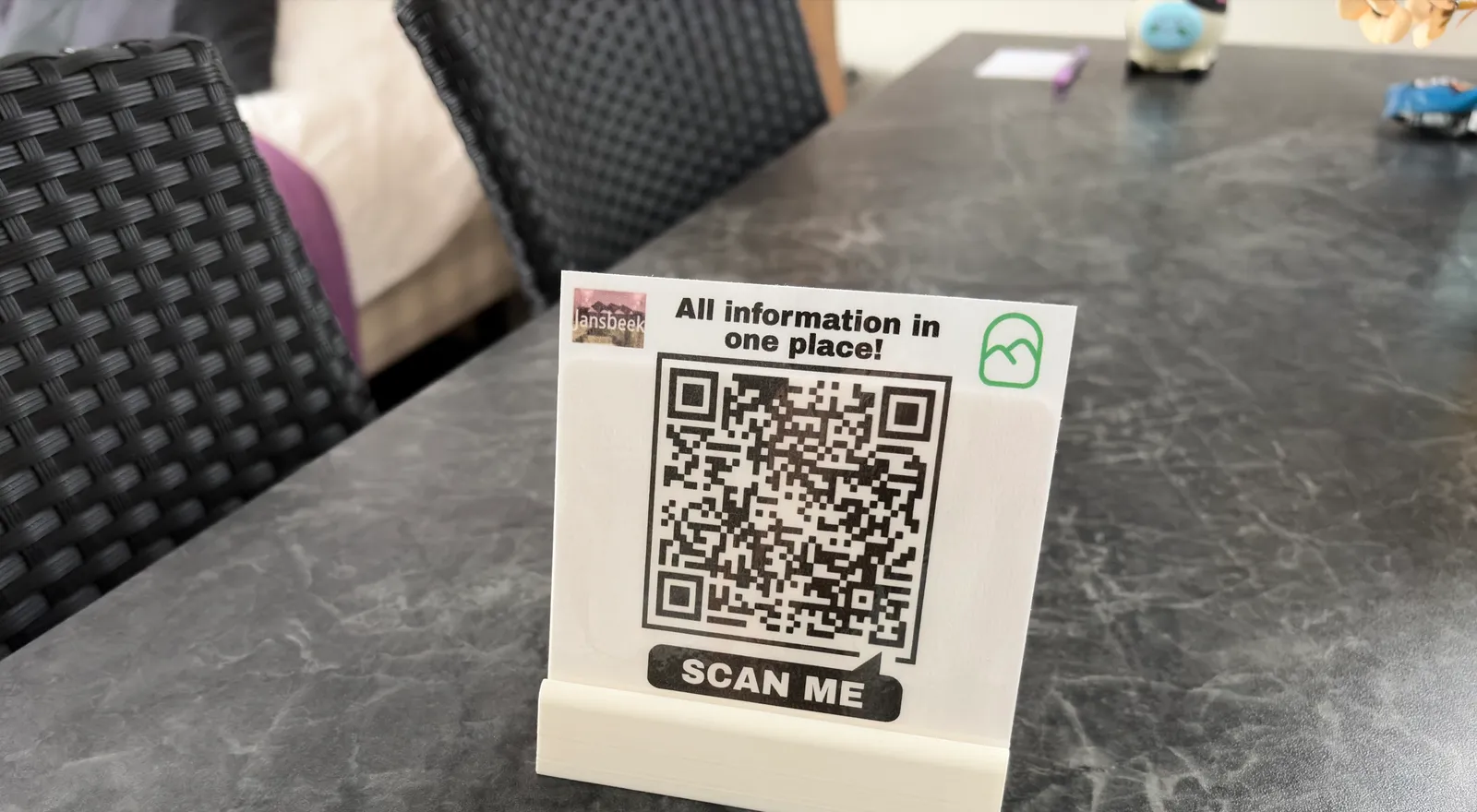 Een geprint QR-kaartje in een standaard op de tafel van een kamer bij Bed & Brownies Jansbeek in Arnhem